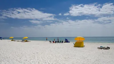 a group of people sitting on a beach with umbrellas at Mistral 6 in Seacrest