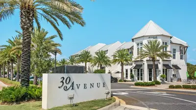 a sign in front of a building with palm trees at Mistral 6 in Seacrest