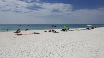 a group of people sitting on a beach with umbrellas at Mistral 10 in Seacrest