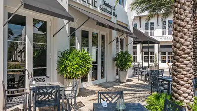 a restaurant with tables and chairs in front of a building at Mistral 10 in Seacrest