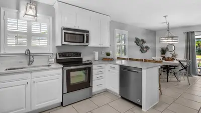 a kitchen with white cabinets and a stove top oven at Beachwood Villas 4G in Santa Rosa Beach