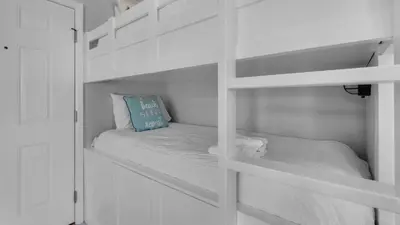 a white bunk bed with a blue pillow on it at Beachwood Villas 4G in Santa Rosa Beach