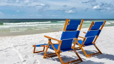 two blue beach chairs sitting on the beach at Monterey Condos A302 in Panama City Beach
