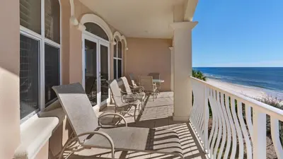 a balcony with chairs and a table and the beach at Monterey Condos A302 in Panama City Beach