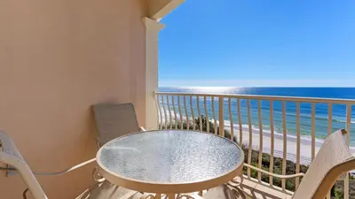 a balcony with a table and chairs and the ocean at Monterey Condos A302 in Panama City Beach