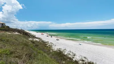 a beach with people on the sand and the ocean at Monterey Condos A302 in Panama City Beach