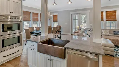 a kitchen with a sink and a living room at Blue Bungalow in Santa Rosa Beach