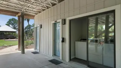 an open glass door on a house with a patio at Beachfront Condo II 202A - Out of the Blue in Santa Rosa Beach