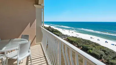 a balcony with a table and chairs and the beach at Monterey Condos B302 in Panama City Beach