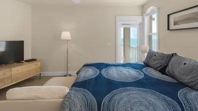 a bedroom with a bed and a couch and a television at Monterey Condos B302 in Panama City Beach