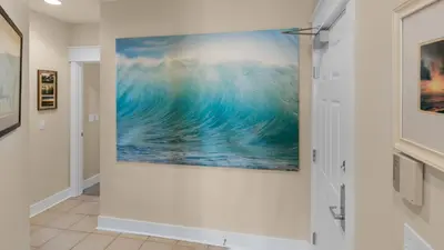 a painting of a wave on a wall in a hallway at Monterey Condos B302 in Panama City Beach