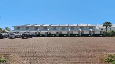 a large white building with cars parked in a parking lot at Blue Nine 9 in Panama City Beach