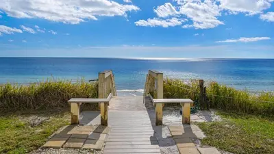 two benches sitting on a wooden walkway to the beach at Blue Tide 3B in Panama City Beach