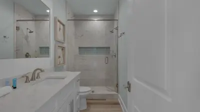 a white bathroom with a shower and a toilet at Resting Beach Face in Rosemary Beach