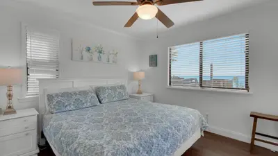 a bedroom with a bed and a ceiling fan at Beachside Condo 1 in Santa Rosa Beach