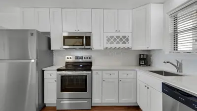a white kitchen with a stove and a microwave at Beachside Condo 1 in Santa Rosa Beach