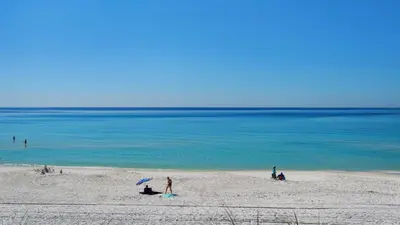a group of people on a beach near the water at Beachside Condo 1 in Santa Rosa Beach