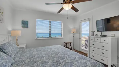 a bedroom with a bed and a ceiling fan at Beachside Condo 1 in Santa Rosa Beach