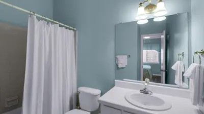 a bathroom with a sink and a toilet and a mirror at Palms A3 in Santa Rosa Beach