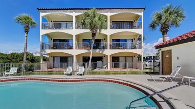 a hotel with a swimming pool in front of a building at Palms A3 in Santa Rosa Beach