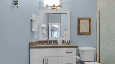 a bathroom with a sink and a toilet and a mirror at Palms A12 in Santa Rosa Beach