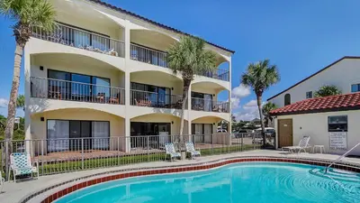 a hotel with a swimming pool in front of a building at Palms A12 in Santa Rosa Beach