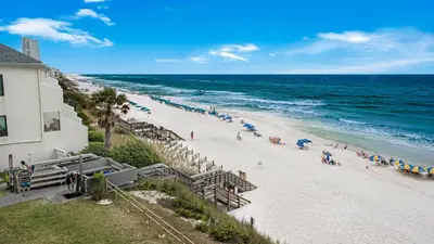 a view of a beach with a building and the ocean at Beachside Condo 11 in Santa Rosa Beach