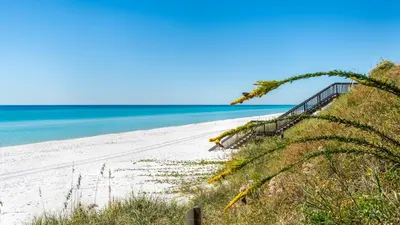 a sandy beach with a staircase leading to the ocean at Beachside Condo 11 in Santa Rosa Beach