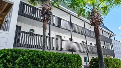 two palm trees in front of a building at Beachside Condo 13 in Santa Rosa Beach