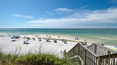 a group of people on a beach with the ocean at Beachside Condo 13 in Santa Rosa Beach
