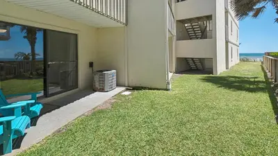 a building with blue chairs and a balcony with the ocean at Beachside Condo 14 in Santa Rosa Beach