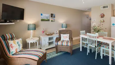 a living room with a table and chairs and a tv at Beachside Condo 14 in Santa Rosa Beach
