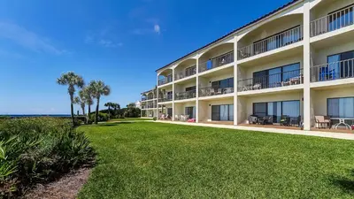 a large apartment building with a lawn in front of the ocean at Palms C4 in Santa Rosa Beach