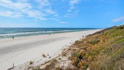 a beach with people walking on the sand and the ocean at Palms C5 in Santa Rosa Beach