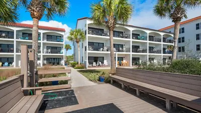 a building with palm trees in front of it at Palms C5 in Santa Rosa Beach