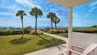 a porch with a view of the ocean and palm trees at Palms C5 in Santa Rosa Beach