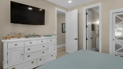 a bedroom with a white dresser with a tv on the wall at Palms C7 in Santa Rosa Beach