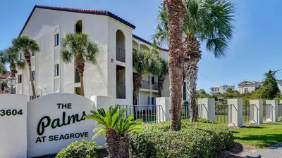 a sign in front of a building with palm trees at Palms C7 in Santa Rosa Beach