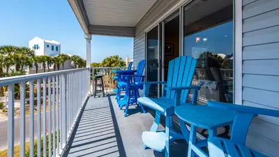 a row of blue chairs sitting on a porch at Beachside Villas 221 in Santa Rosa Beach