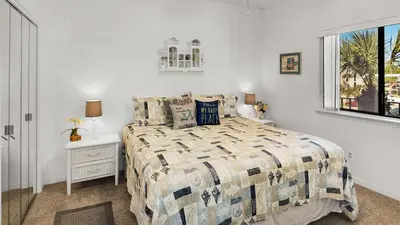 a bedroom with a bed and a window at Palms C11 in Santa Rosa Beach