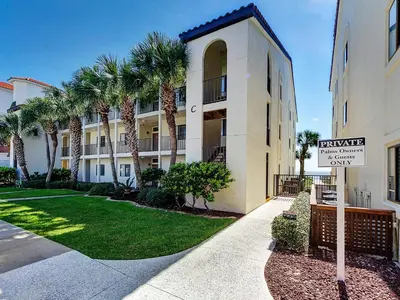 a street sign in front of a building with palm trees at Palms D7 in Santa Rosa Beach