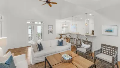 a living room with a white couch and a table at Grateful By the Sea in Santa Rosa Beach