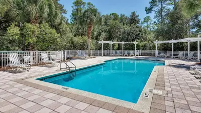a swimming pool in a yard with a fence at Grateful By the Sea in Santa Rosa Beach