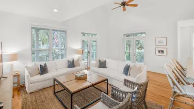 a living room with a couch and a table at Grateful By the Sea in Santa Rosa Beach