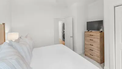 a bedroom with a bed and a television on a dresser at Grateful By the Sea in Santa Rosa Beach