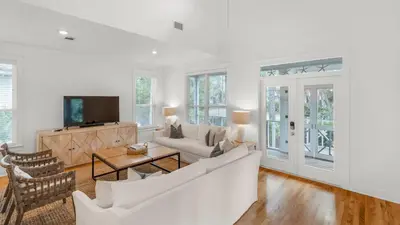 a living room with a couch and a tv at Grateful By the Sea in Santa Rosa Beach