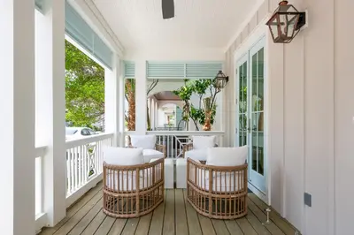 a porch with wicker chairs and a table at Maison de Joie in Inlet Beach