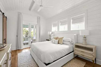 a white bedroom with a bed and a window at Maison de Joie in Inlet Beach