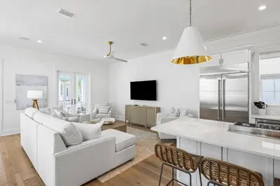 a white living room with a white couch and a table at Maison de Joie in Inlet Beach