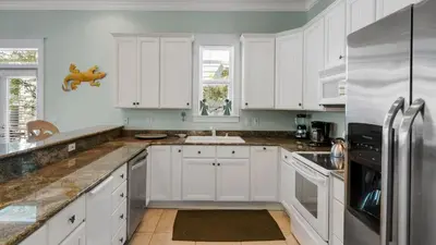 a kitchen with white cabinets and a sink at Pink Flamingo in Panama City Beach
